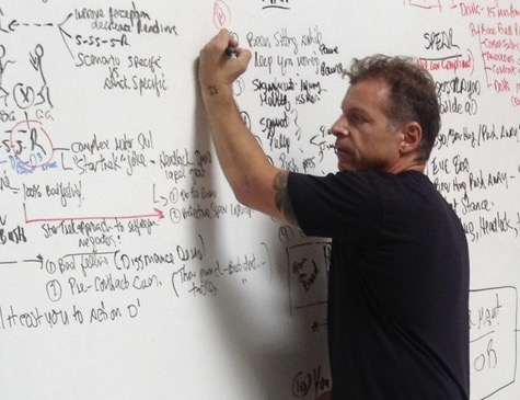 Coach Blauer mapping out a scenario on the whiteboard during a live session